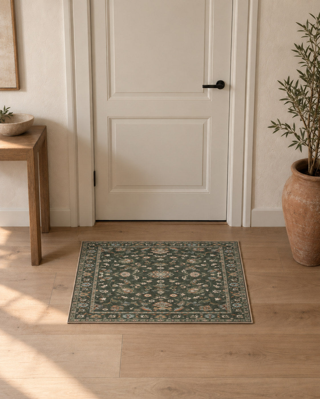 Tapis d'entrée persan vintage vert olive, posé devant une porte